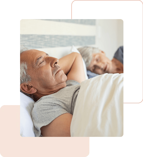 Casal de idosos descansando em uma cama, representando tranquilidade e qualidade de vida após a realização de um exame do sono.